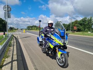 Policjant na motorze stojący na poboczu drogi