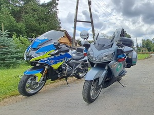 Dwa motocykle stojące na poboczu, jeden policyjny drugi  Inspektoratu Transportu Drogowego.
