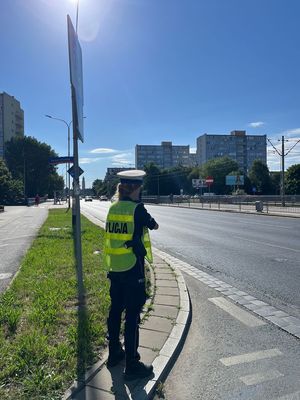 Policjantka mierzy prędkość ręcznym miernikiem prędkości