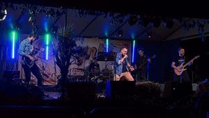 Czterech rockowych muzyków na scenie, jedne śpiewa reszta gra na instrumentach.