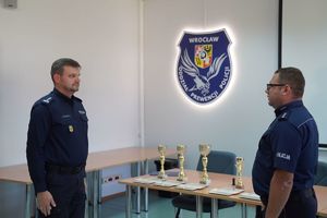 Policjant składa meldunek Zastępy Komendanta Wojewódzkiego Policji inspektorowi Norbertowi Kurendzie