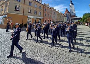 Orkiestra policyjna Policji we Wrocławiu podczas koncertu na świeżym powietrzu.