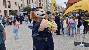 Podczas festynu Komisarz Lew (maskotka policyjna) trzyma na rękach chłopca