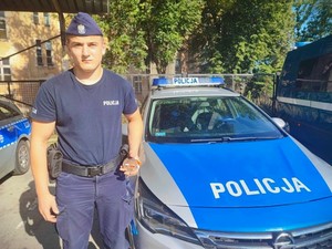 Policjant stojący przy radiowozie