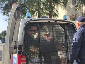 policjant prowadzi zatrzymanego
