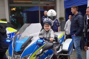 Chłopczyk siedzący na motorze policyjnym podczas pikniku