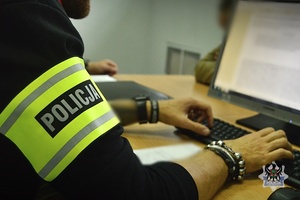 Policjantka pisze na klawiaturze komputera