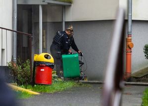 Policjantka pomaga osobie z chodzikiem wydostać się z płonącego budynku