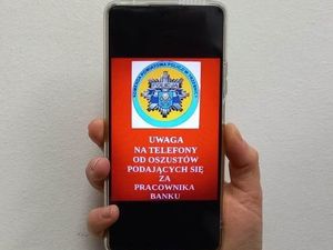 telefon trzymany w ręku z wyświetlonym napisem