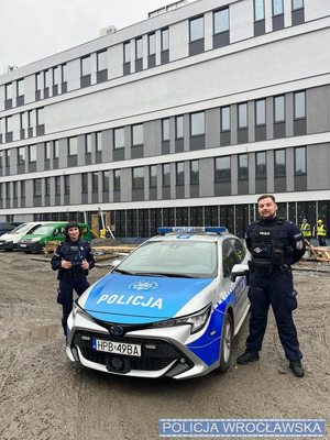 policjant i policjantka przy radiowozie na dworze