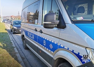 Bus policyjny na drodze szybkiego ruchu a za nim zatrzymany samochód osobowy