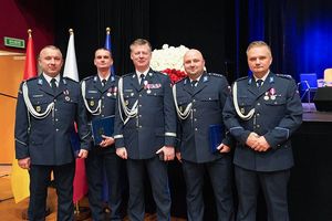 Komendant Wojewódzki Policji we Wrocławiu nadinspektor Dariusz Wesołowski na wspólnym zdjęciu z czterema odznaczonymi policjantami.
