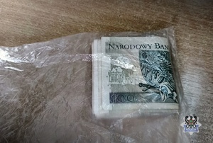 Zwinięte banknoty po 100 złotych znajdujące się w woreczku.