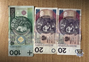 Trzy banknoty leżące na blacie stołu