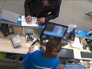 Mężczyzna wypełnia dokumenty przy kasie sklepowej