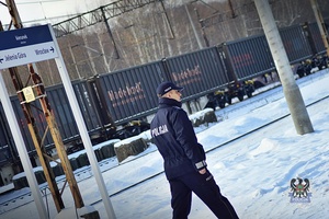 Policjant porą zimową idzie peronem