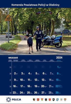 Kalendarz na wrzesień Komendy Powiatowej Policji w Oleśnicy - na zdjęciu policjant z motorem i przechodzący przez pasy chłopiec.