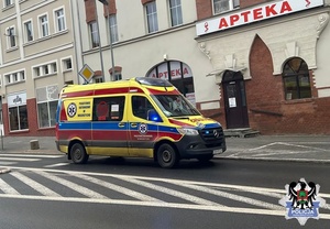Karetka pogotowia stojąca na poboczu koło apteki