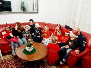 Policjanci z dziećmi siedzący na sofie