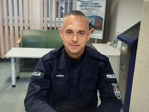 Umundurowany policjant siedzący przy biurku