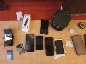 Telefony komórkowe, karty bankomatowe leżące na stole