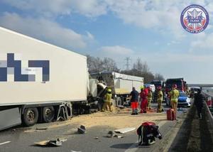 Zdjęcie z wypadku na autostradzie: dwa tiry po zderzeniu i pracujące na miejscu służby ratunkowe