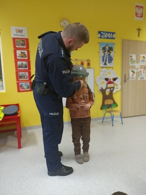 Policjant zakłada dziecku kask