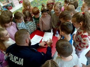 Policjant pokazuje dzieciom jak odciska się palce