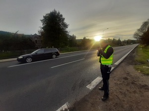 Policjant mierzy prędkość jadącym drogom pojazdom
