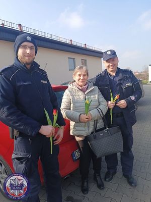 Policjanci rozdają kobietą tulipany