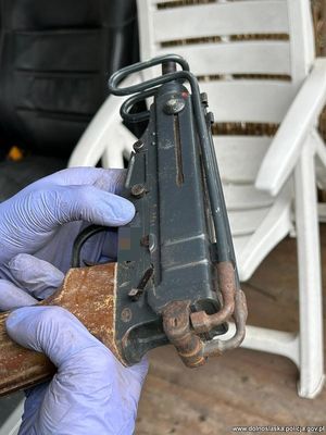 Pistolet trzymany w rękach z założonymi rękawiczkami