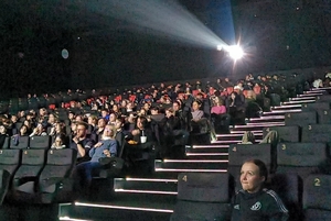 Młodzież siedząca w sali kinowej