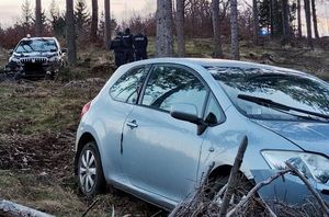 Samochód osobowy w jasnym kolorze w tle nieoznakowany radiowóz policyjny, trzej policjanci i dwaj zatrzymani