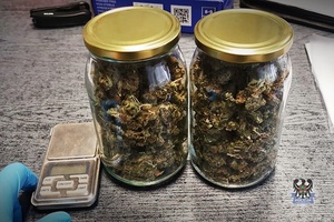 Susz marihuany w dwóch słoikach, obok waga