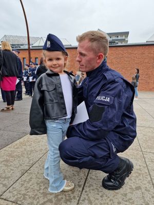 Nowo przyjęty policjant pozuje do zdjęcia z córką