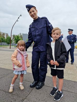 Nowo przyjęta policjantka pozuje do zdjęcia z dziećmi