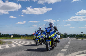 policjanci jadący na dwóch motocyklach droga krajową