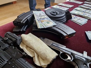 Przedmioty znalezione w przeszukiwanych mieszkaniach - broń i banknoty
