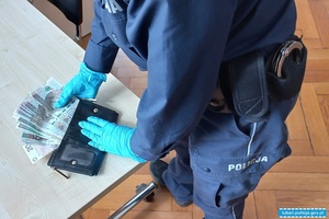 Mężczyzna w rękawiczkach wyciąga z portfela banknoty w polskim nominale rozłożone w wachlarz