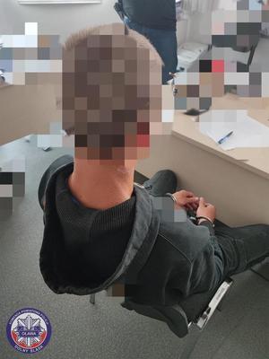 Zatrzymany siedzący na krześle podczas przesłuchania