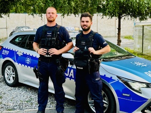 Policjanci na tle radiowozu