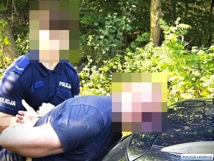 mężczyzna skuty kajdankami i policjant