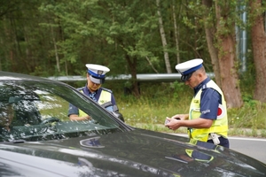 Policjanci ruchu drogowego kontrolujący pojazdy poruszające się ulicami