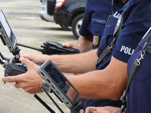 policjanci z monitorami z dronów