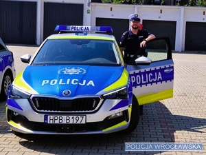 Policjant obok radiowozu