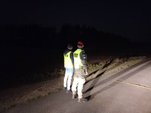 Pora nocna - policjant i żołnierz obserwują drogę