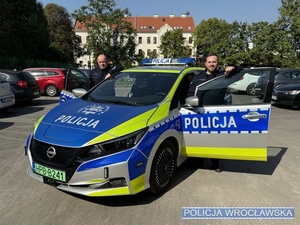 Policjanci stojący przy radiowozie