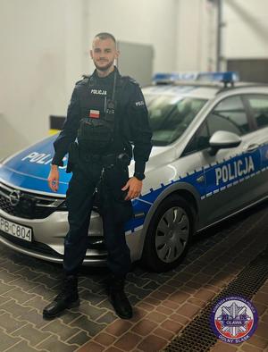 policjant stojący przy radiowozie