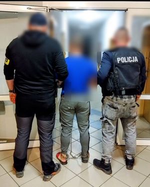 dwaj policjanci prowadzą zatrzymanego