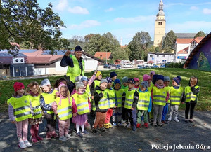 wspólne zdjęcie policjantów z przedszkolakami w kamizelkach odblaskowych